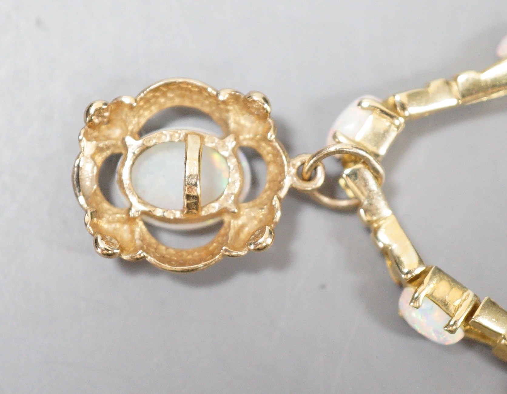 A modern 585 yellow metal and fourteen stone opal set drop bracelet, 19.3cm, gross weight 10.7 rams.